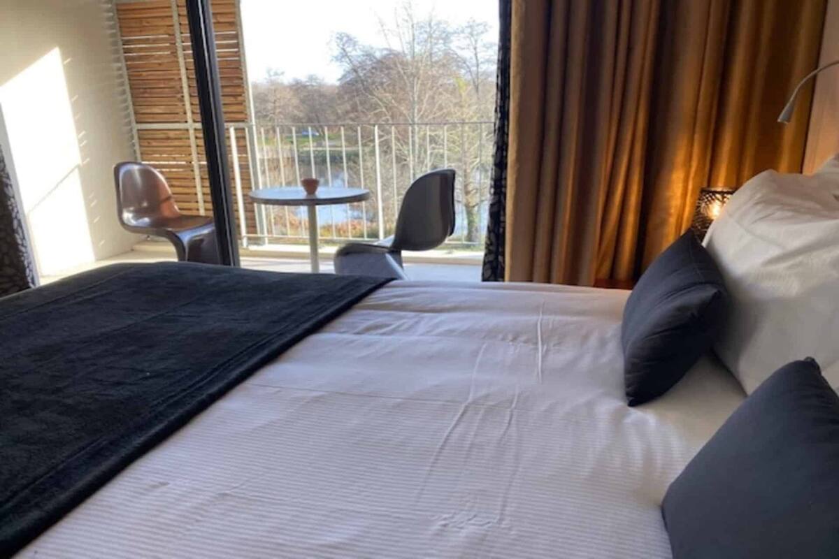 Ett hotellrum med en säng, ett litet bord och en stol.