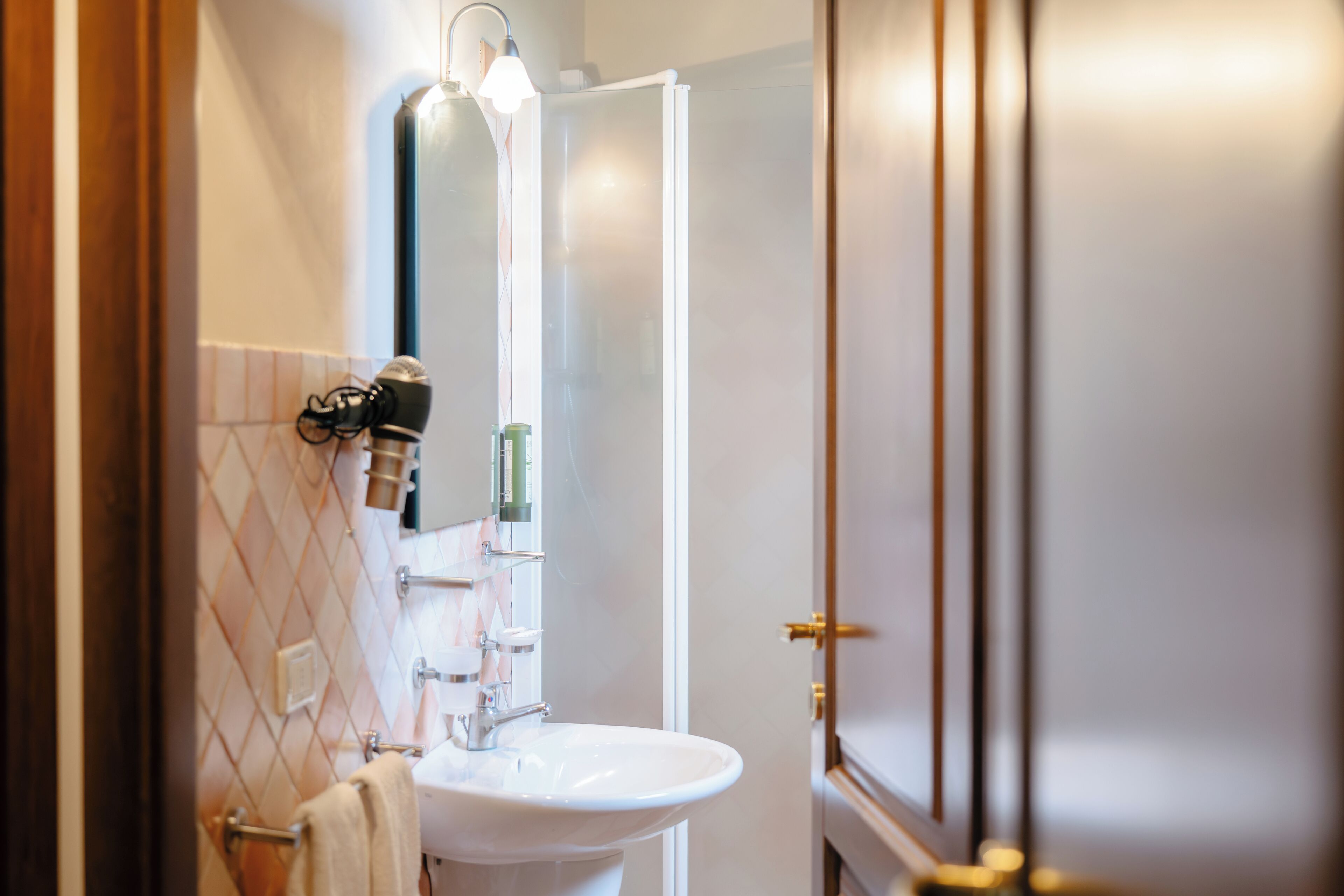 A bathroom with a white sink, a towel rack, and a mirror.