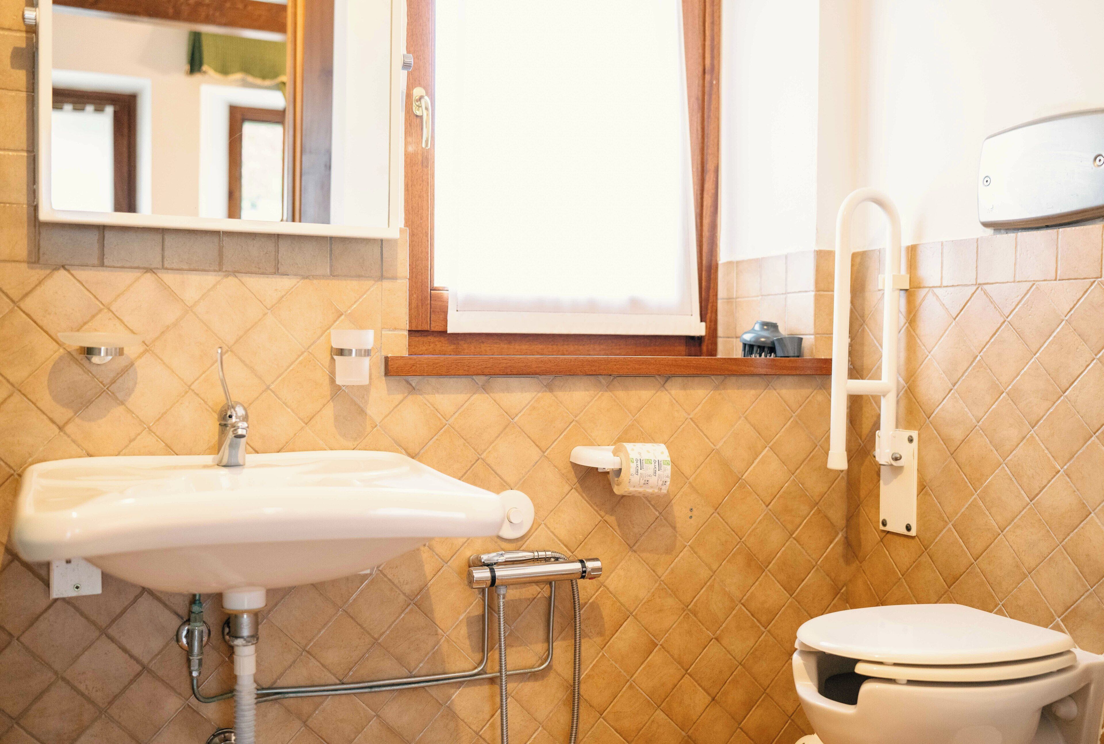 Ein Badezimmer mit Waschbecken, Toilette und Fenster.