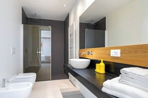 A modern bathroom with a large mirror, a white sink, a bidet, and a towel rack. - House on the Langhe - Luxury private Pool, Sauna and Jacuzzi (Diano D'alba)