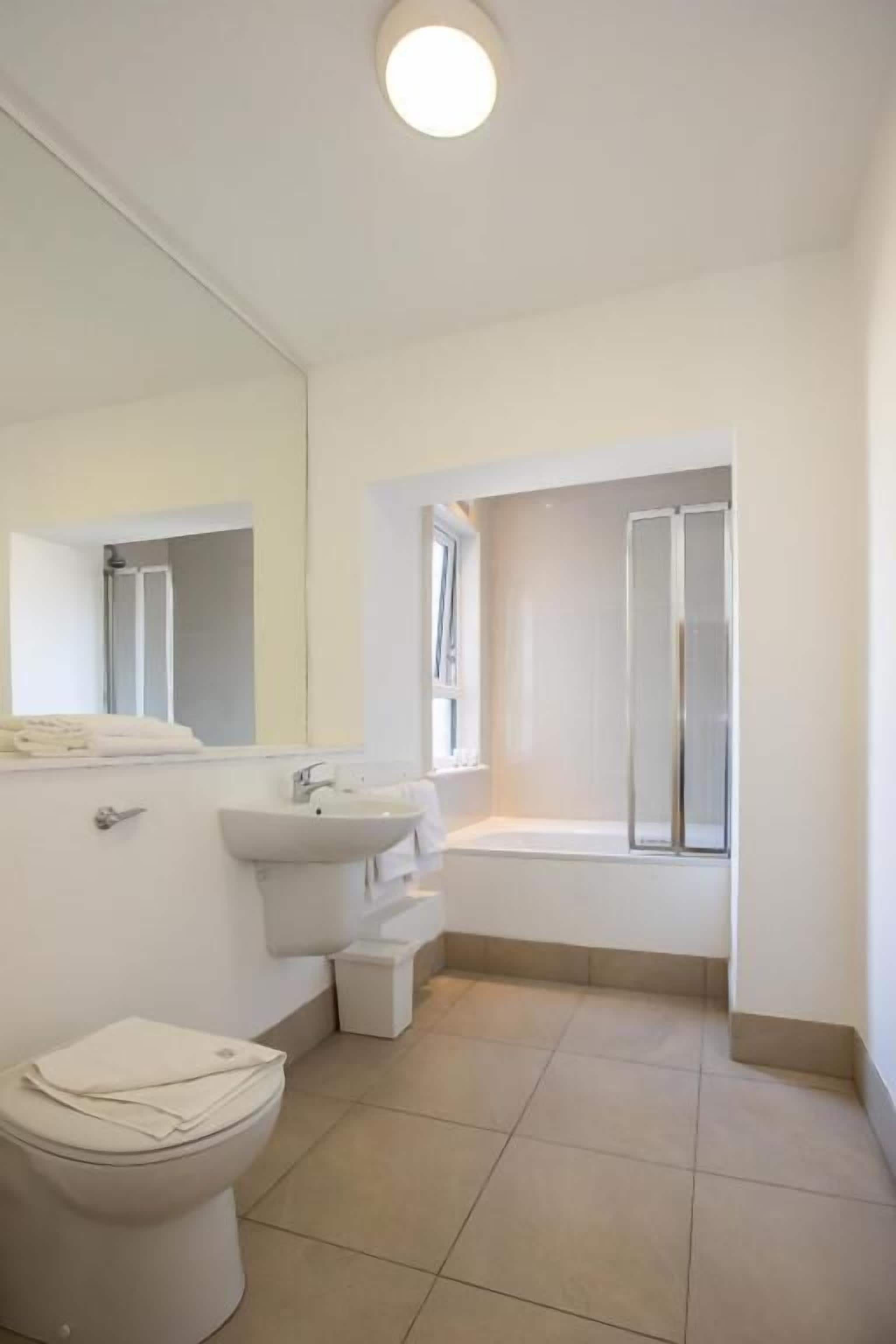 Ein Badezimmer mit Toilette, Waschbecken und Dusche.