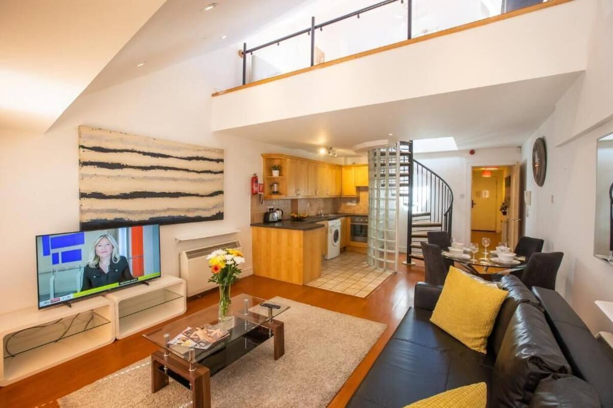 Een modern appartement met een woonkamer, keuken en een eethoek.