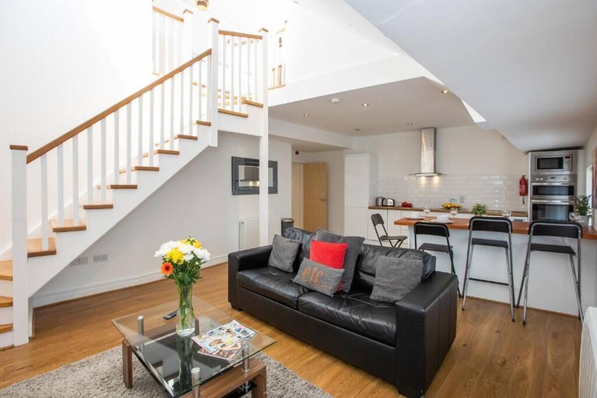 Een modern appartement met woonkamer, keuken en wenteltrap.