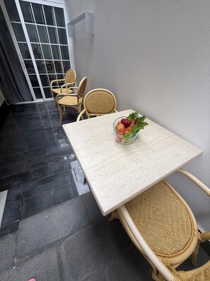 A dining area with a table, chairs, and a bowl of fruit.