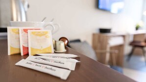 A table with coffee cups, packets of sugar, and a sugar container. - Central St. Gallen Studio (blue): Fast WiFi & kitchen for shared use (St. Gallen)