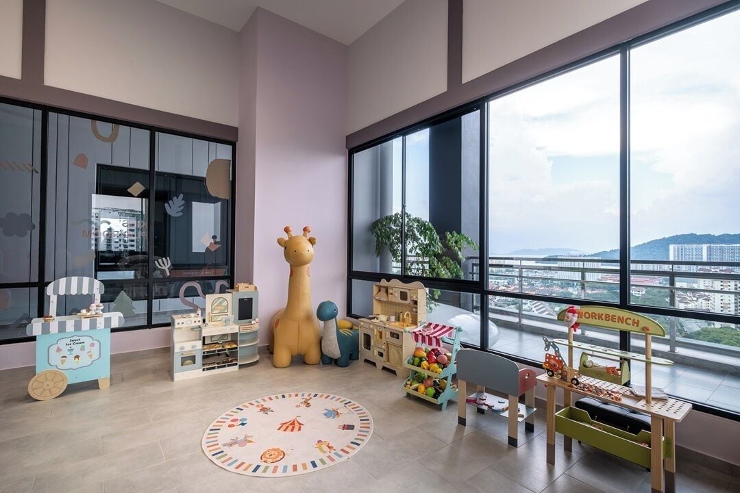 A children's playroom with large windows, a giraffe toy, and various play structures.