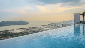 An infinity pool with a view of a cityscape and a bridge. - Iconic Regency Service Residences - Managed by Iconic Hotel (George Town)