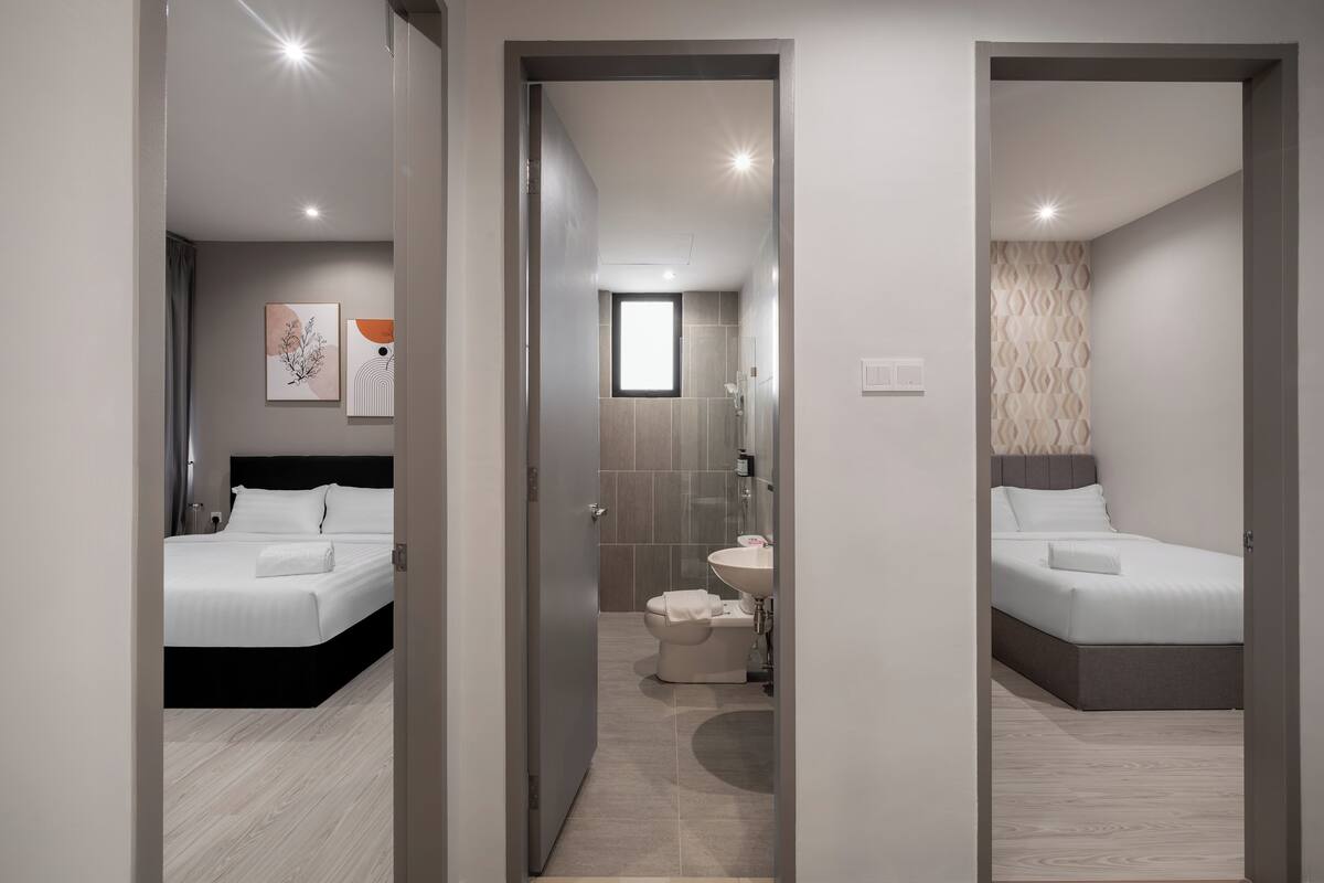A modern hotel room with a large bed, a separate bathroom, and a small sitting area.