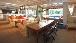 A spacious living area with a dining table, sofas, and a fireplace. - Explorers Club (Franschhoek)