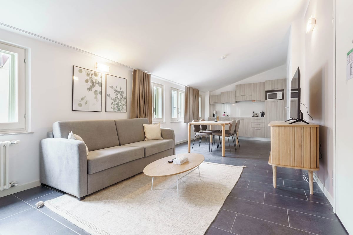 Ein modernes Wohnzimmer mit Sofa, Couchtisch und Kunstwerk an der Wand.
