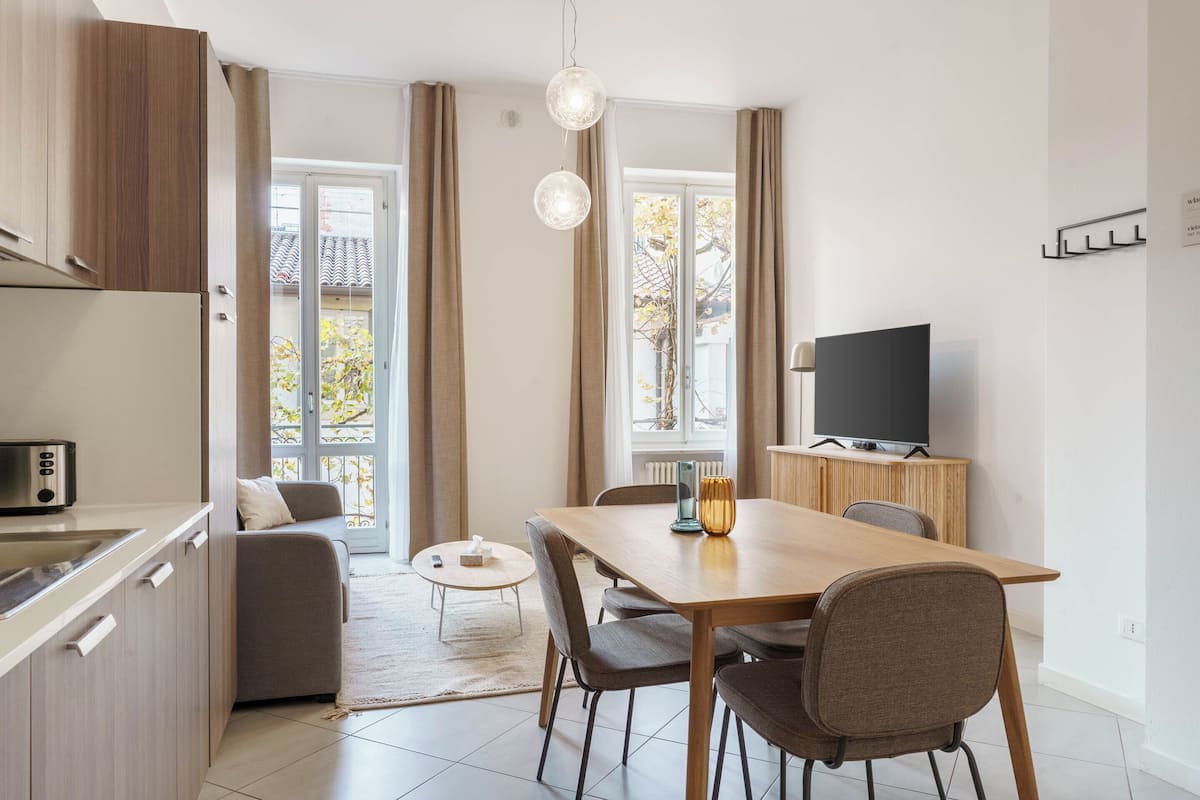 Eine moderne Küche mit Essbereich, einer Sitzecke und einem Fernseher.