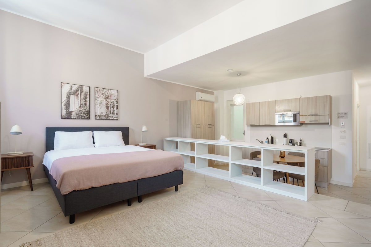Ein modernes Schlafzimmer mit einem großen Bett, Nachttischen und einer weißen, integrierten Regaleinheit.