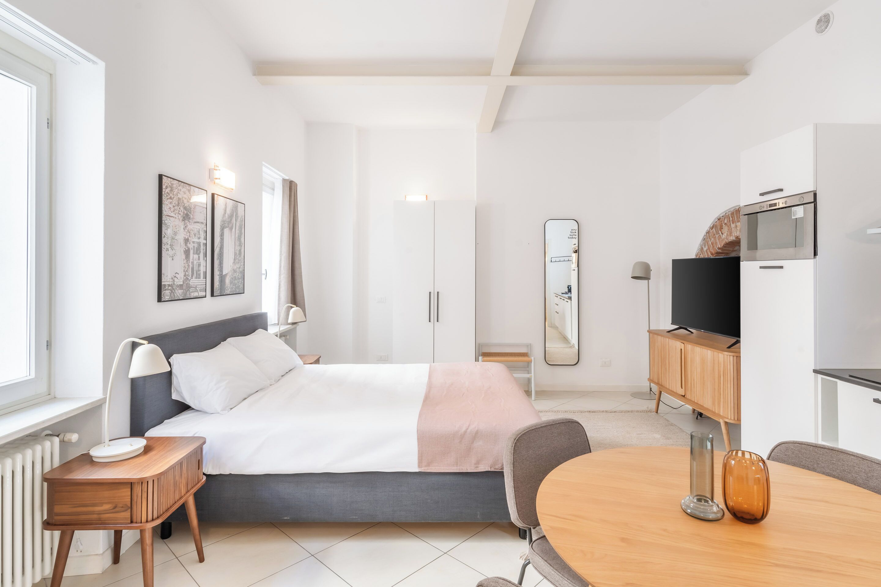 Une chambre à coucher moderne avec un lit, une table de chevet et un téléviseur.