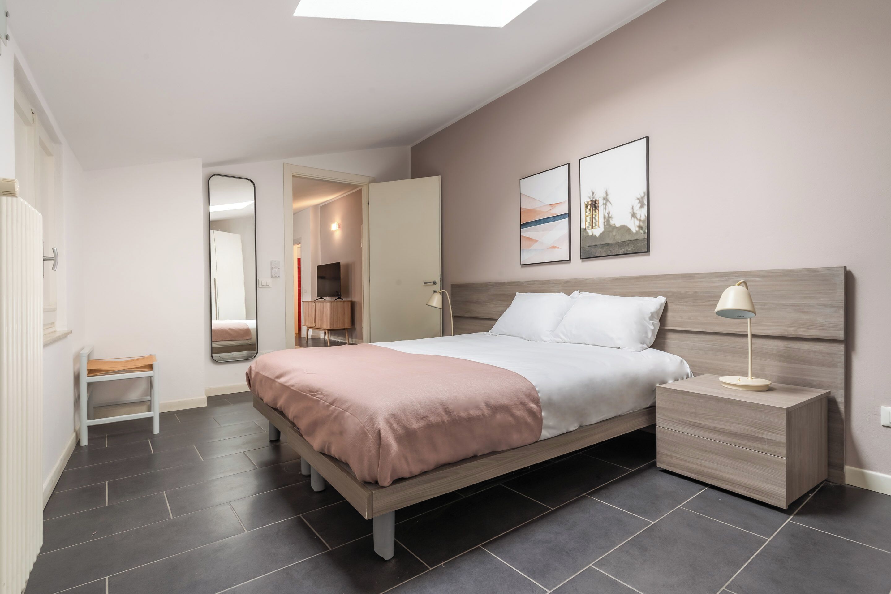 Une chambre à coucher moderne avec un lit, une table de chevet et un miroir.