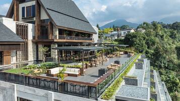 A modern building with a rooftop patio area featuring outdoor seating and a view of the surrounding landscape.
