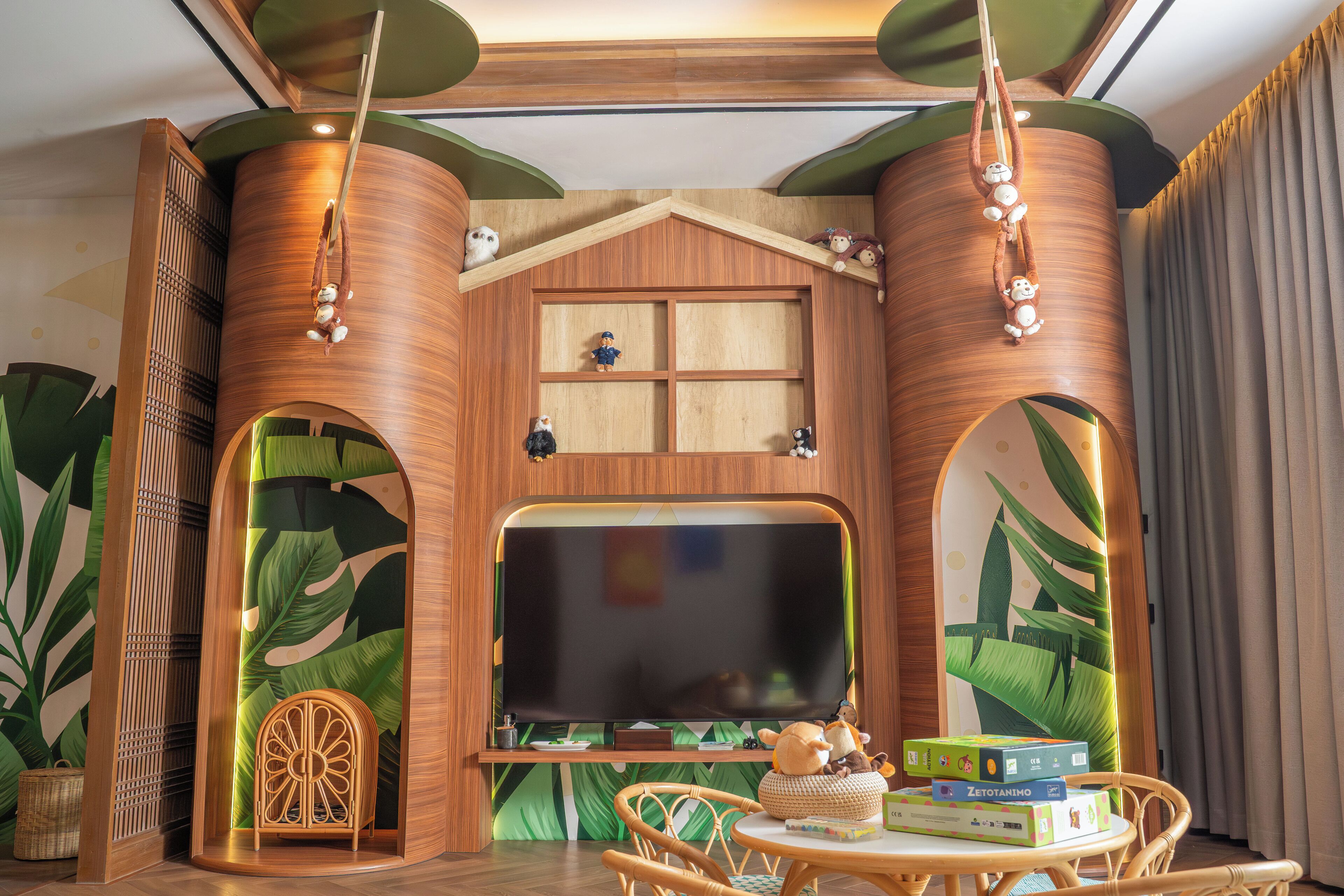 A room with a large flat-screen TV, wooden decor, a small table with items, and a chair.