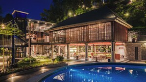 Un hôtel moderne doté d’une piscine, d’un espace extérieur aménagé et d’un jardin bien éclairé.