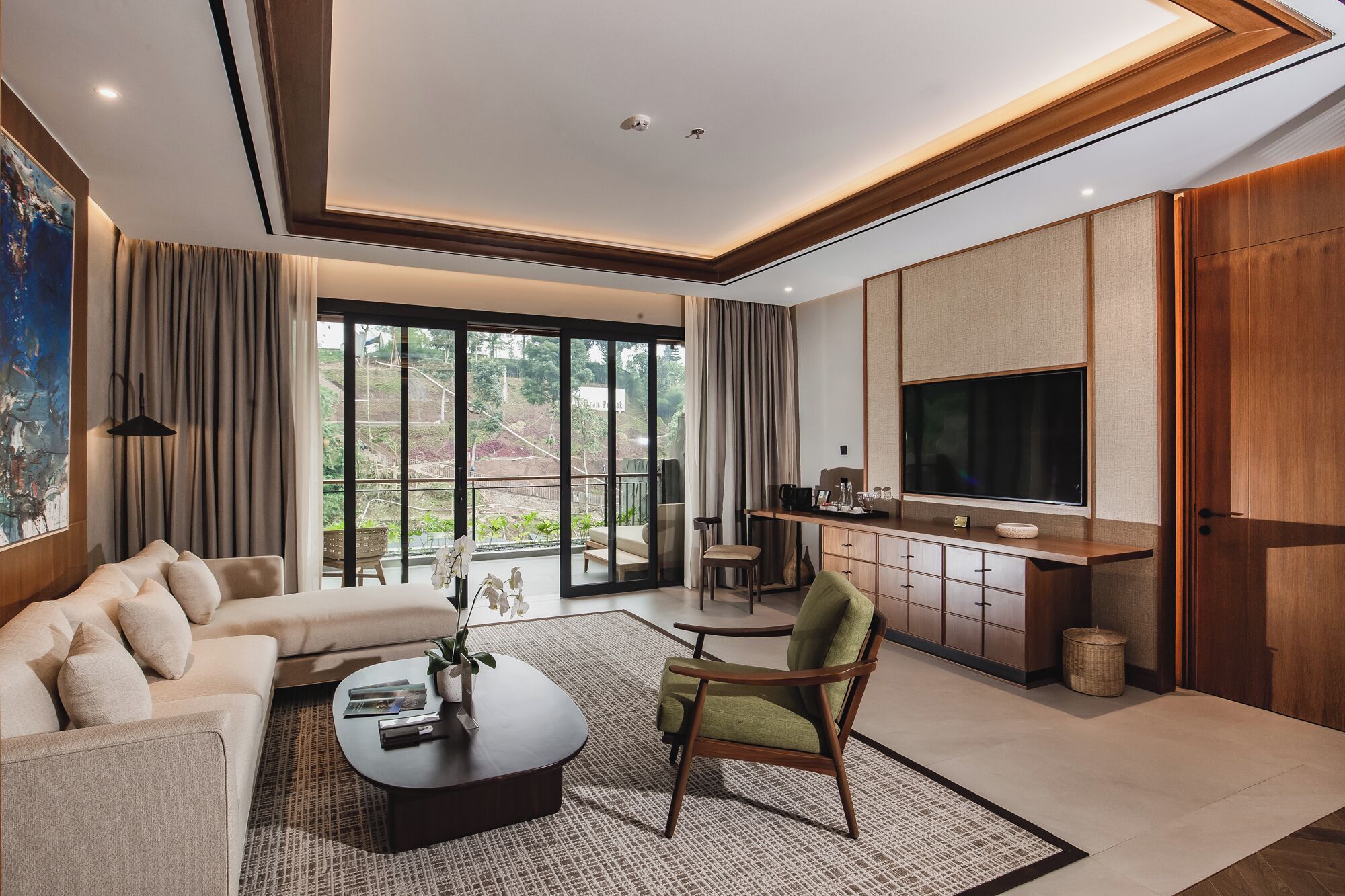 Una sala de estar moderna con sofá, sillón, mesa de centro y televisor.