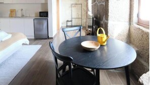 A cozy dining area with a round table, chairs, and a yellow kettle.