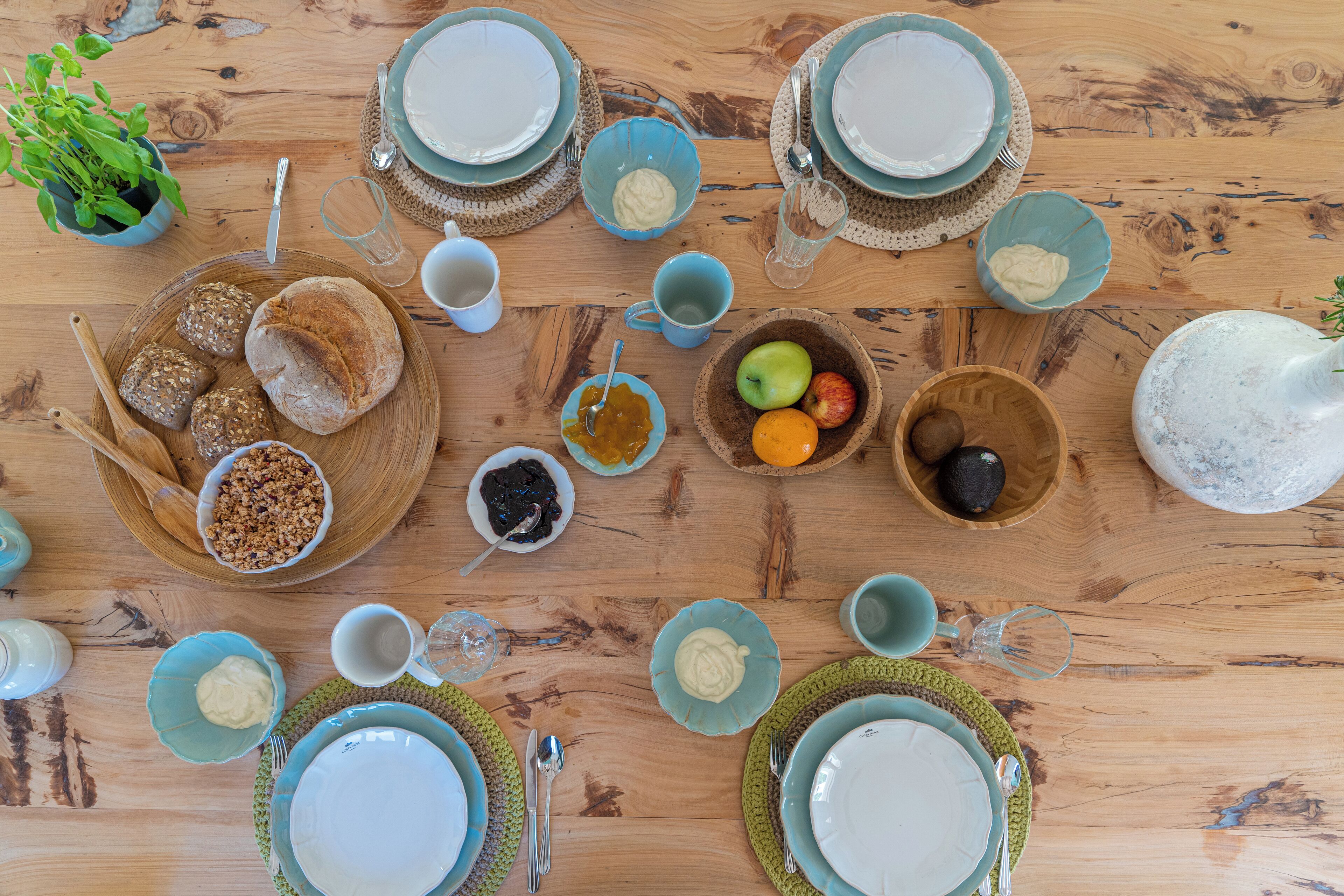 A wooden table with various food items, plates, and bowls.