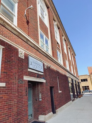 Un immeuble en briques rouges avec une enseigne indiquant « FlyingFish Lofts » et le numéro de porte « 203 ».