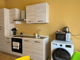 Una cocina compacta con lavamanos, estufa, horno y lavadora.