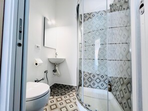 Une salle de bain avec des toilettes, un lavabo et une douche.
