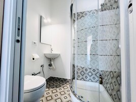 Un baño con inodoro, lavamanos y ducha.