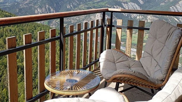 A balcony with a wicker chair and a glass table, overlooking a mountainous landscape. - Renovated 2P apartment on slopes, quiet, Pra Loup (Pra-Loup)