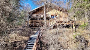 A wooden cabin with a staircase leading to a deck.