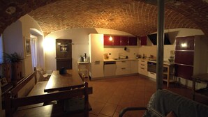 Une cuisine rustique avec un plafond en briques, une table à manger en bois et des équipements de base.