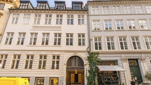 A building with multiple windows, a visible entrance, and a parked yellow van. - Tivoli 2 - Spacious 3 Bedroom Near Tivoli (Copenhagen)