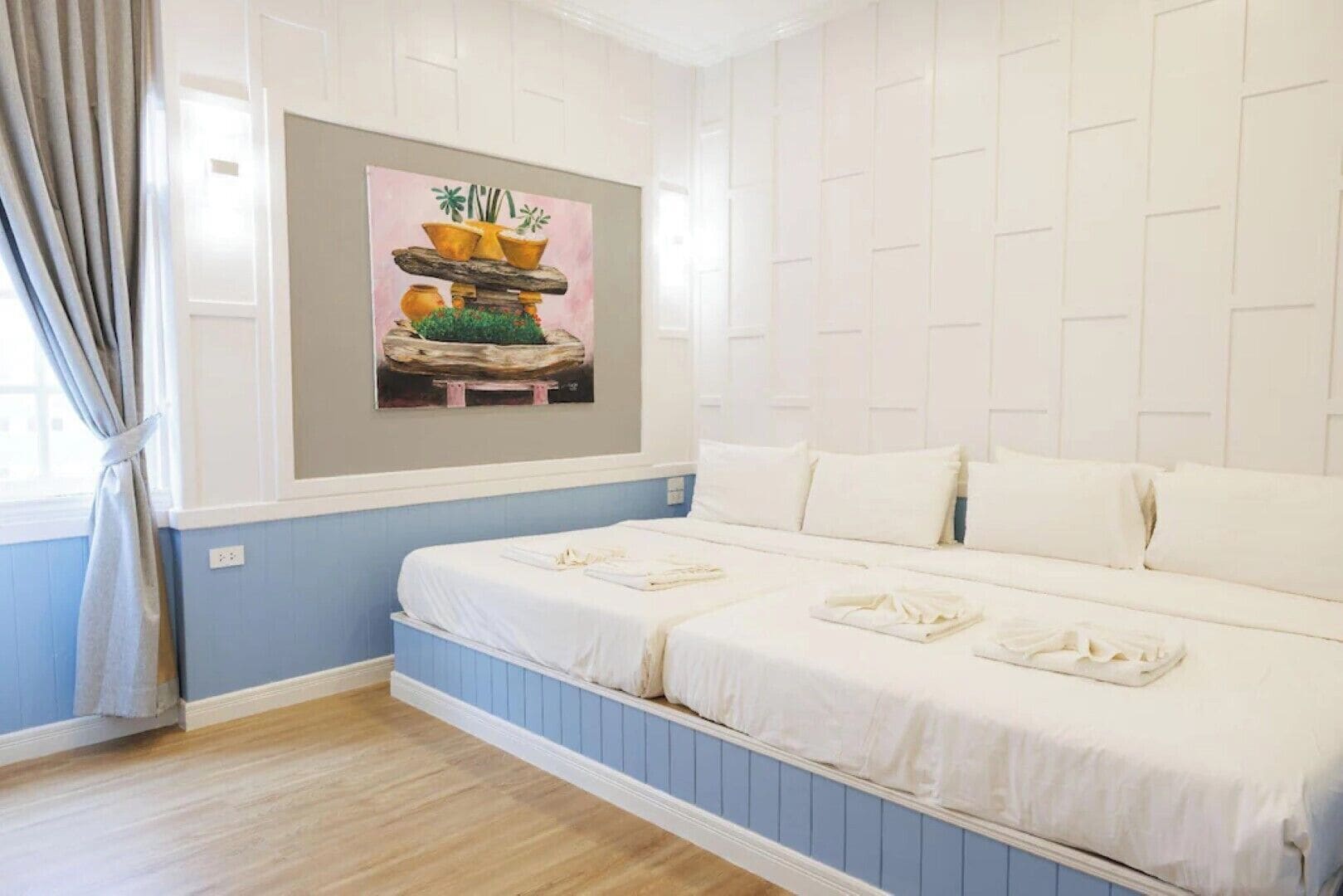 Un dormitorio con cama, una ventana con cortinas y un cuadro en la pared.