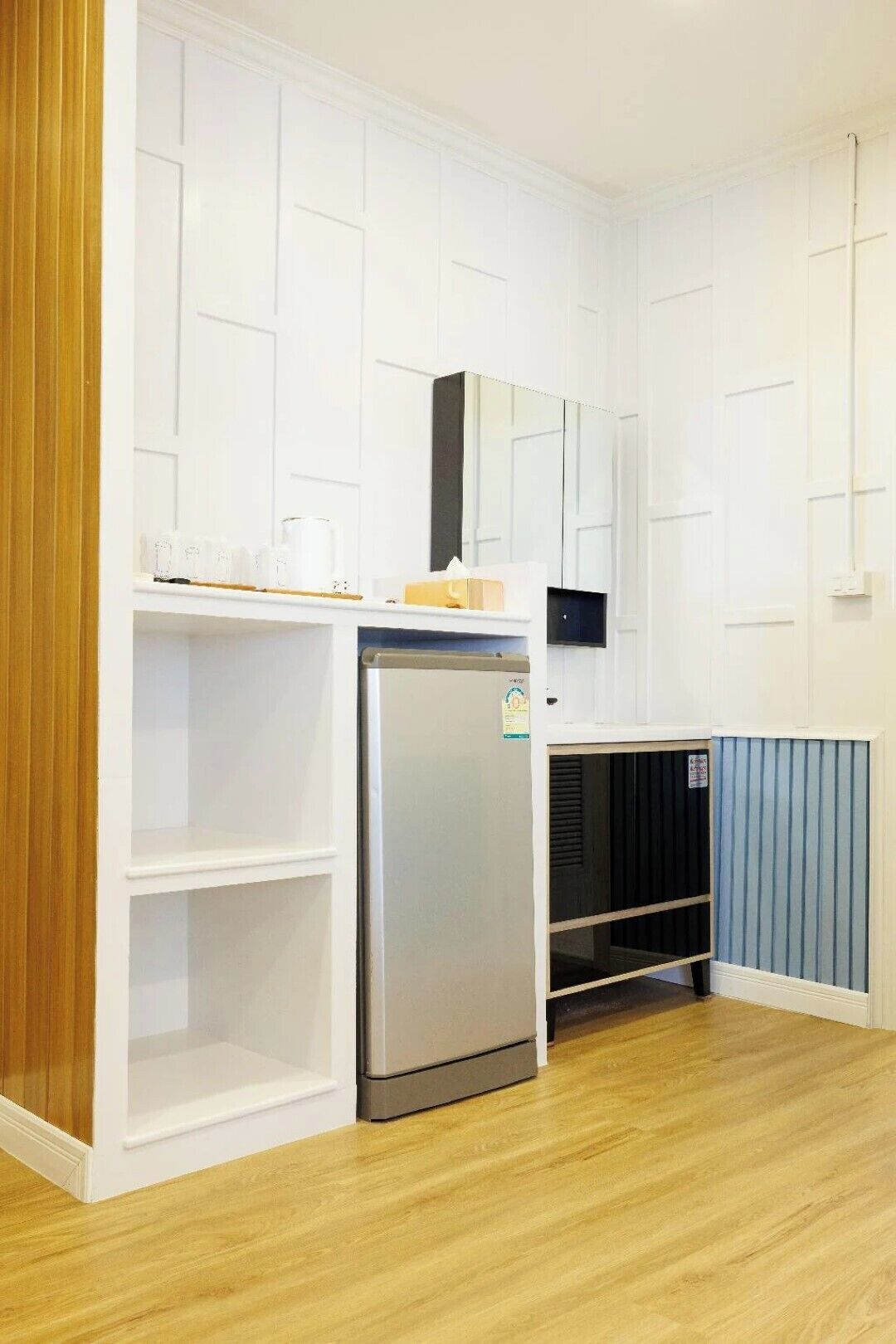 A compact kitchenette with a built-in refrigerator, a microwave, and a small countertop.