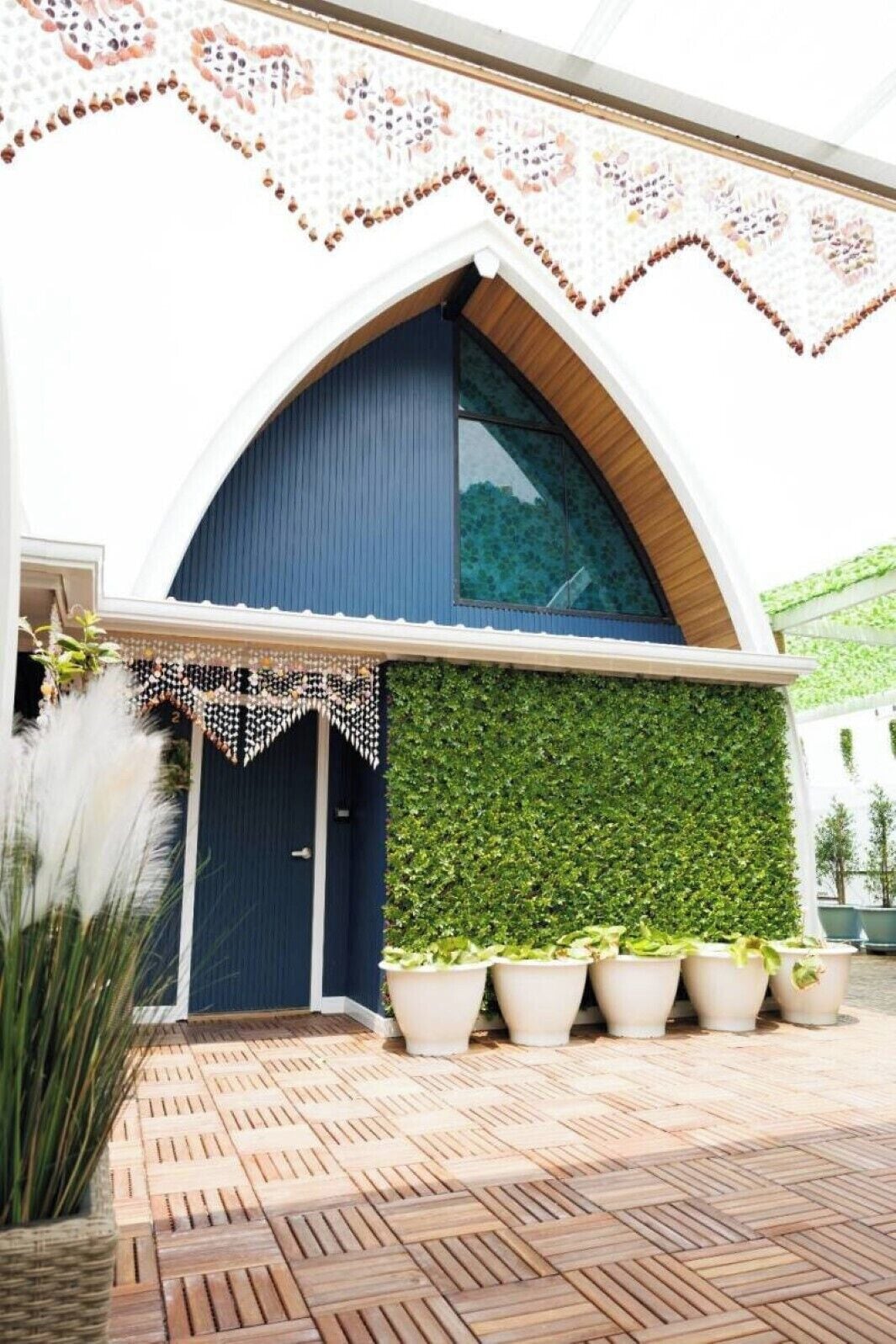 A building with a blue door, a green wall, and a patterned ceiling.