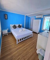 Un dormitorio con una cama, un armario blanco y una mesita.