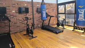 A gym with exercise equipment, including treadmills and stationary bikes, and punching bags. - Luxury Loft 2 Levels in Boutique Lodge 2 Ask About our Free Tour (Victoria Falls)