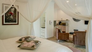 A bedroom with a bed, a desk, and a chair. - Room in Lodge - Luxury Suite in Zambezi Boutique Lodge 2, Free 4x4 Town Tour (Victoria Falls)