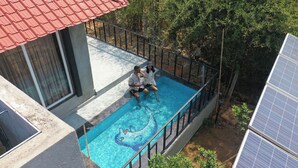 A rooftop pool with a blue mosaic design, surrounded by a metal railing and trees. - Shiv Ganga Kanha Resort (Baihar)