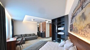 Une chambre d’hôtel moderne équipée d’un lit, d’un bureau, d’un canapé et d’une armoire.
