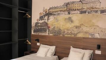 A hotel room with two beds, a wooden headboard, and a large wall mural of a historic building.