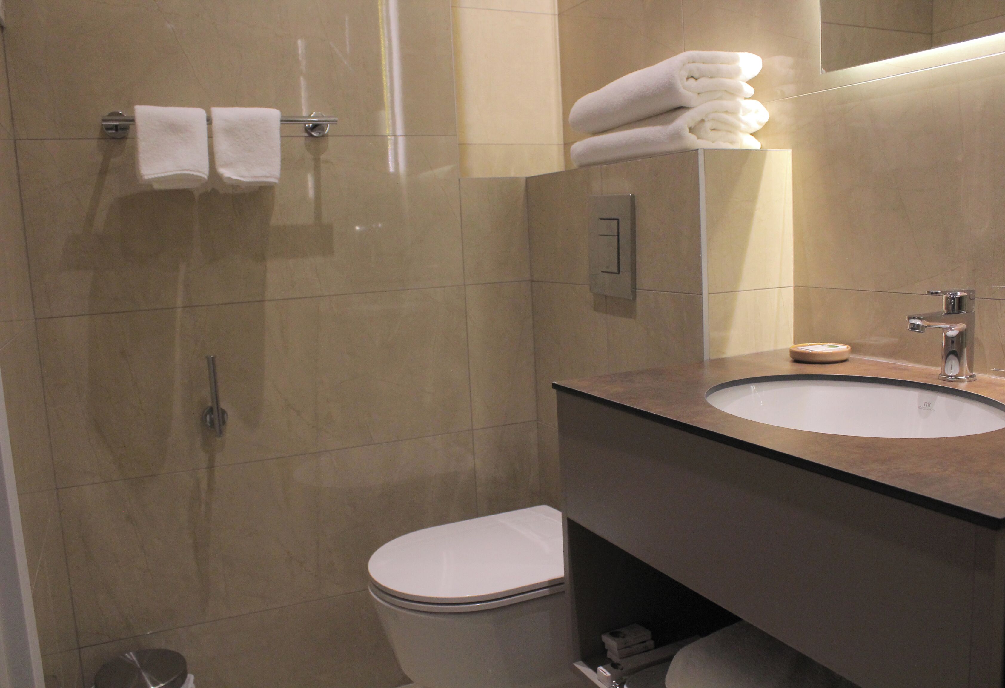 A modern bathroom with a toilet, sink, and shower.