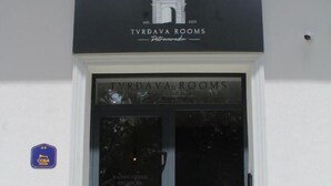 L’entrée de TVRDAVA ROOMS se fait par une porte en verre transparent, au-dessus de laquelle est apposée une enseigne.