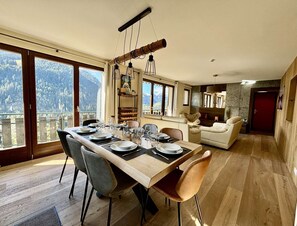 A dining area with a wooden table set for six, surrounded by chairs. - Bartavelles A2 - Charming Apartment in Châtel (Châtel)