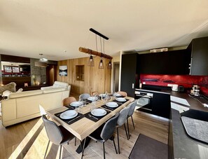 Ein modernes Wohnzimmer mit Essbereich, Küche und einer Couch.