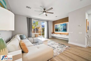 A modern living room with a sofa, coffee table, and a TV mounted on the wall.