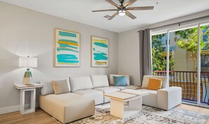 Una sala de estar moderna con un sofá modular, una mesa de centro y dos cuadros abstractos en la pared.