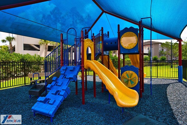 A playground with a slide, climbing structures, and a covered area.