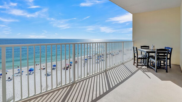 A balcony with a view of a beach and ocean.