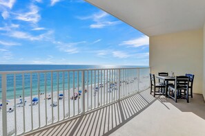 Un balcon avec vue sur une plage et l’océan.